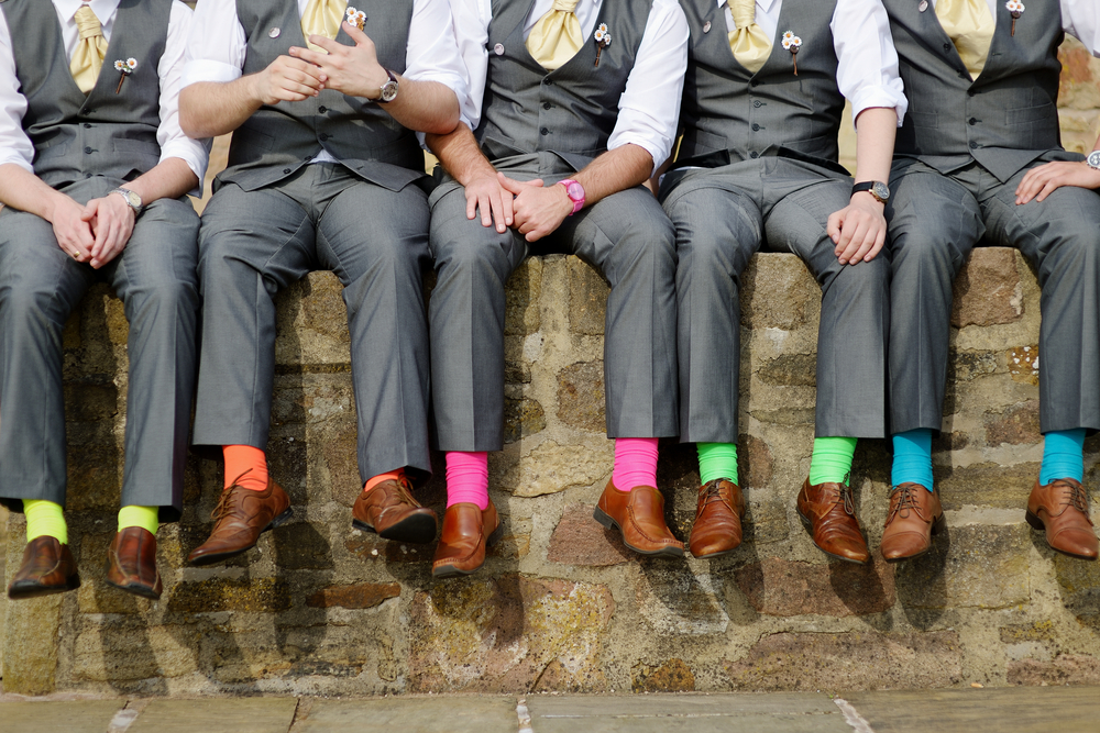Group of guys in suits with colorful socks, preparing for a bachelor party at Club 390.