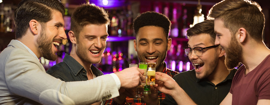 Group of guys enjoying drinks and celebrating at Club 390 during a bachelor party, toasting to an unforgettable night.